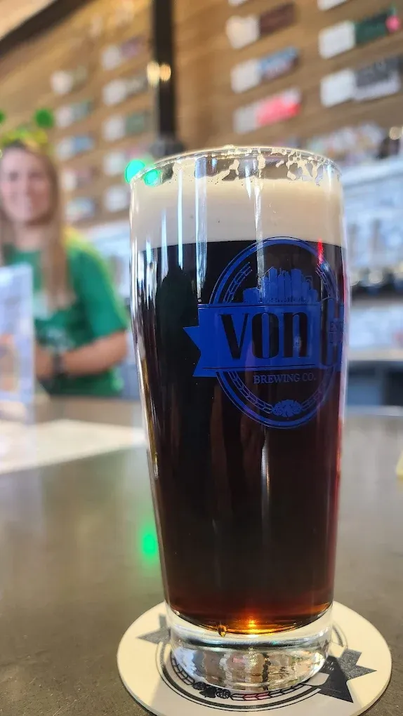 Chalkboard tap list at von C Brewing Co. in Norristown PA showing the rotating lineup of Czech and German lagers and hop-forward ales, live acoustic performance happening under the boards