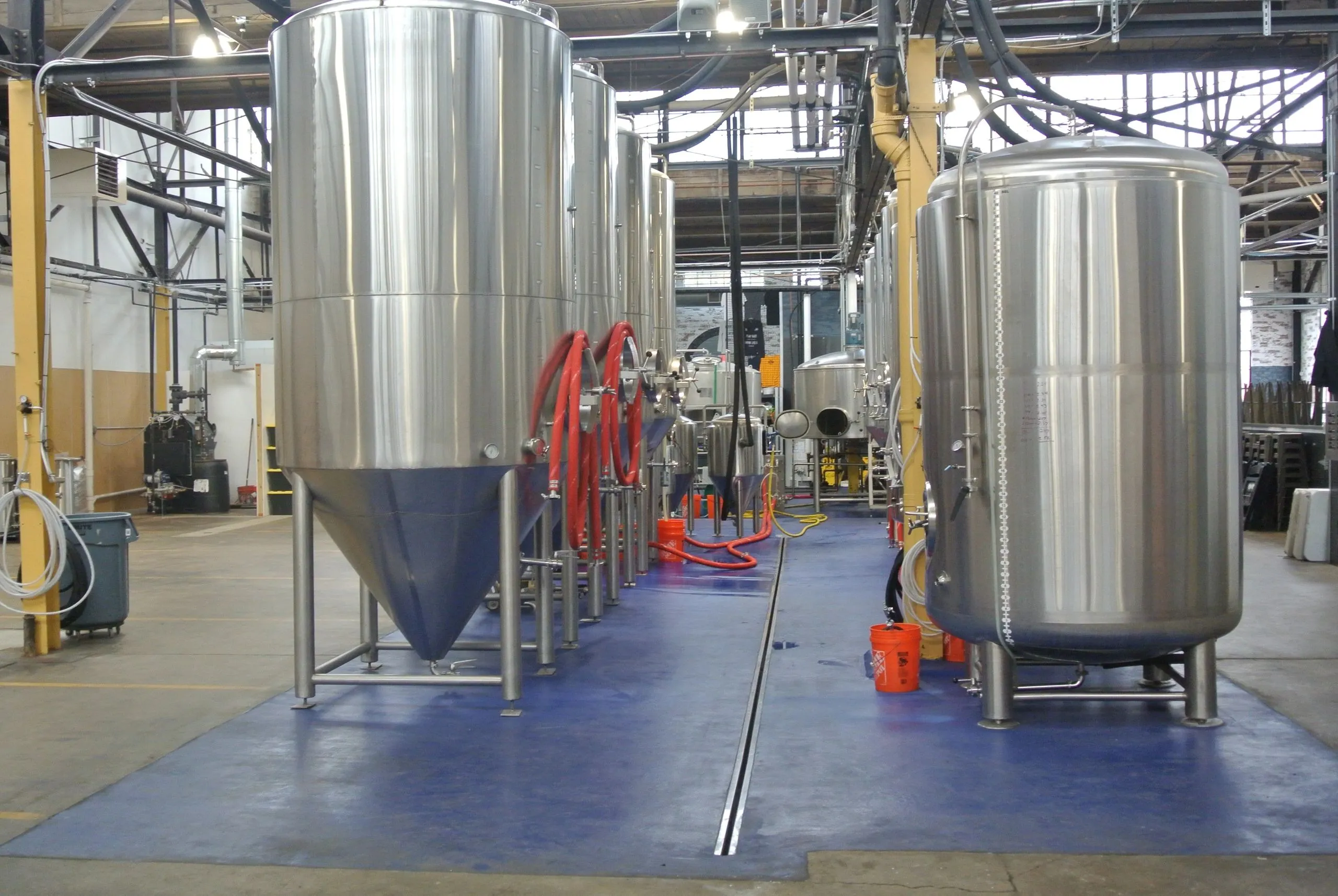 Stainless steel fermentation tanks lined along the back wall of the von C Brewing Co. brewhouse in Norristown — the conditioning tanks where every lager rests four weeks minimum before service